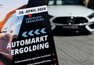 Flyer mit Informationen zum Automarkt Ergolding am 26. April 2026 vor einem weißen Mercedes-Benz auf gepflastertem Platz mit Bäumen im Hintergrund