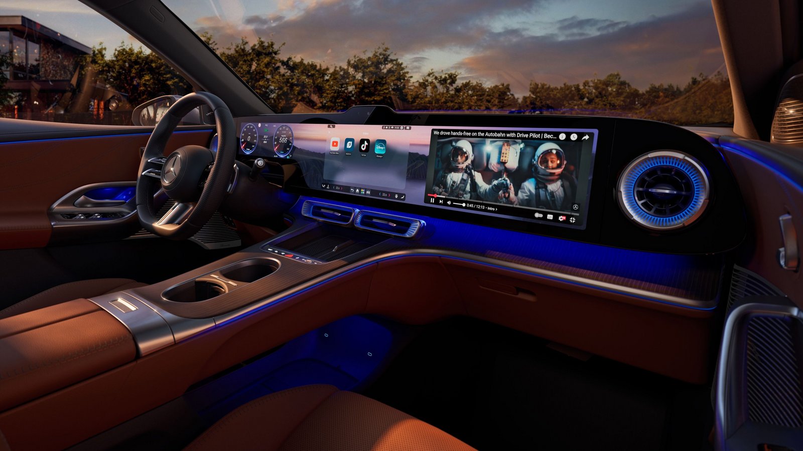 Innenraum eines Mercedes-Benz GLC EQ mit braunen Ledersitzen, digitalem Cockpit und großem Touchscreen-Display bei Dämmerung.