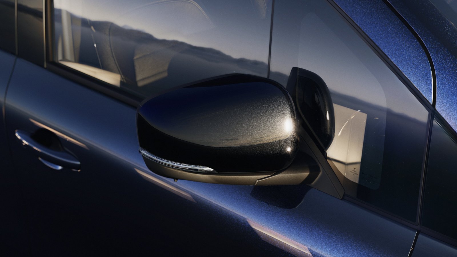 Seitenspiegel des Mercedes-Benz EQT in Nahaufnahme, reflektiert die Umgebung auf glänzender, blauer Lackierung.