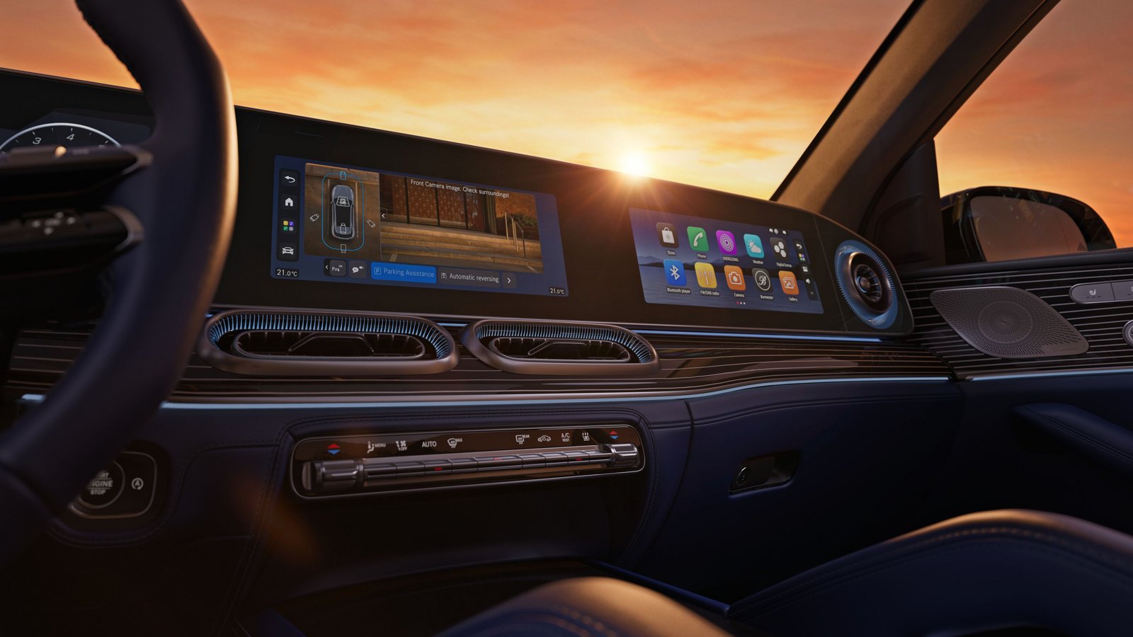 Innenraum des Mercedes-Benz GLE 2026 mit breitem, digitalem Kombiinstrument und Infotainment-Display über einer Holzverkleidung bei Sonnenuntergang