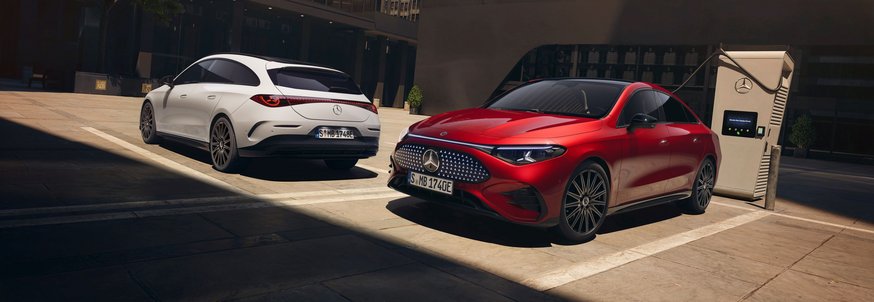 Roter Mercedes-Benz CLA Shooting Brake steht an Ladestation, weißer Mercedes-Benz CLA Shooting Brake parkt daneben in urbaner Umgebung.